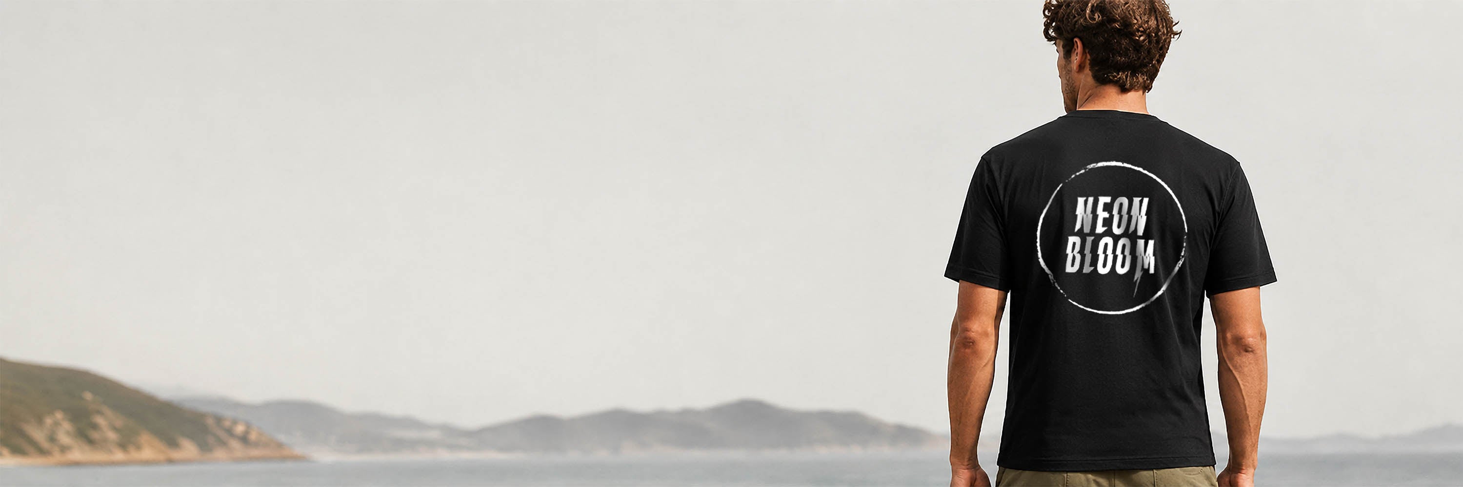 Person wearing a black t-shirt with 'Neon Bloom' logo outdoors