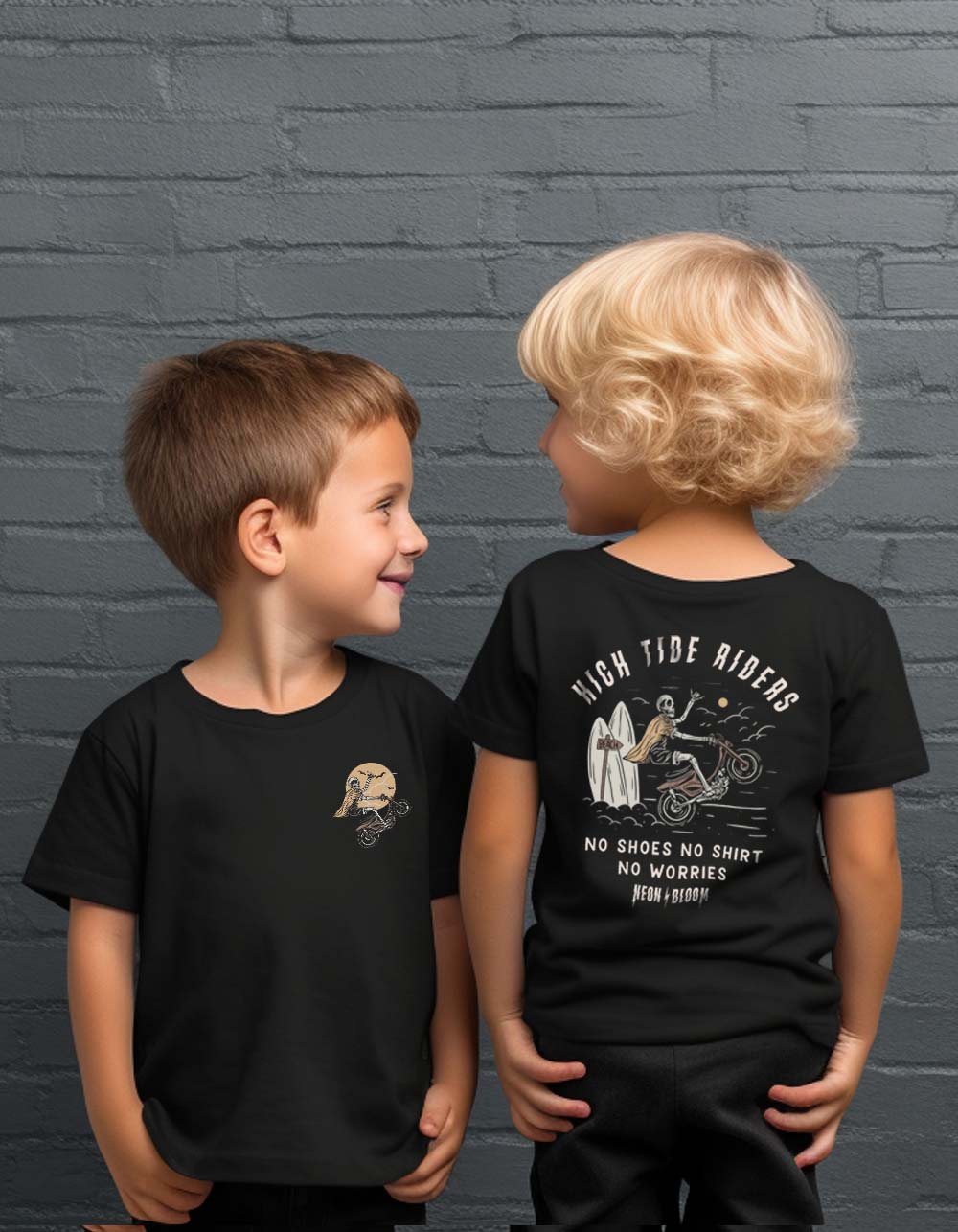 Two children wearing black t-shirts with graphic designs against a gray brick wall.